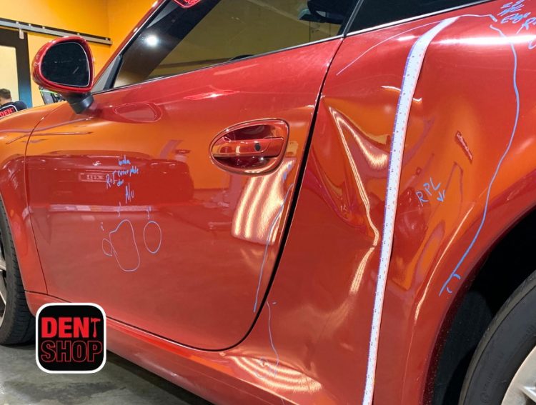 red car getting dent repaired at dent shop